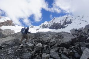 Ben crossing the moraine with our objective Nevado Pisco hiding in the clouds in the background.
